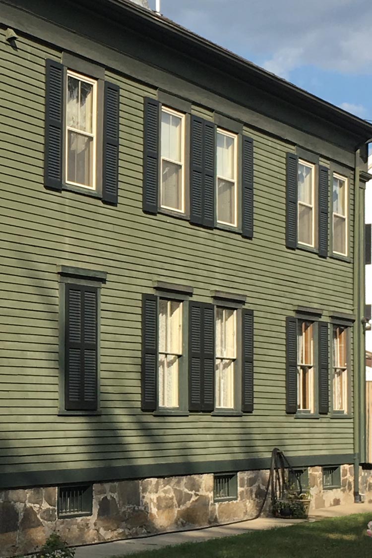 Exterior Green Shutters on a Green House - Wood Louvered Panels